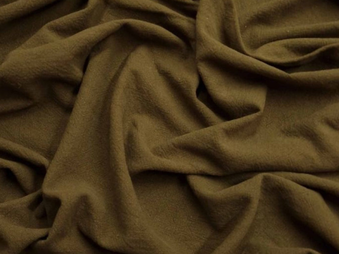 Close-up of brown fabric with folds on a white background
